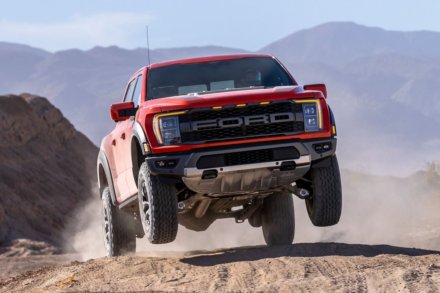  A red 2023 Ford F-150 Raptor jumping off road