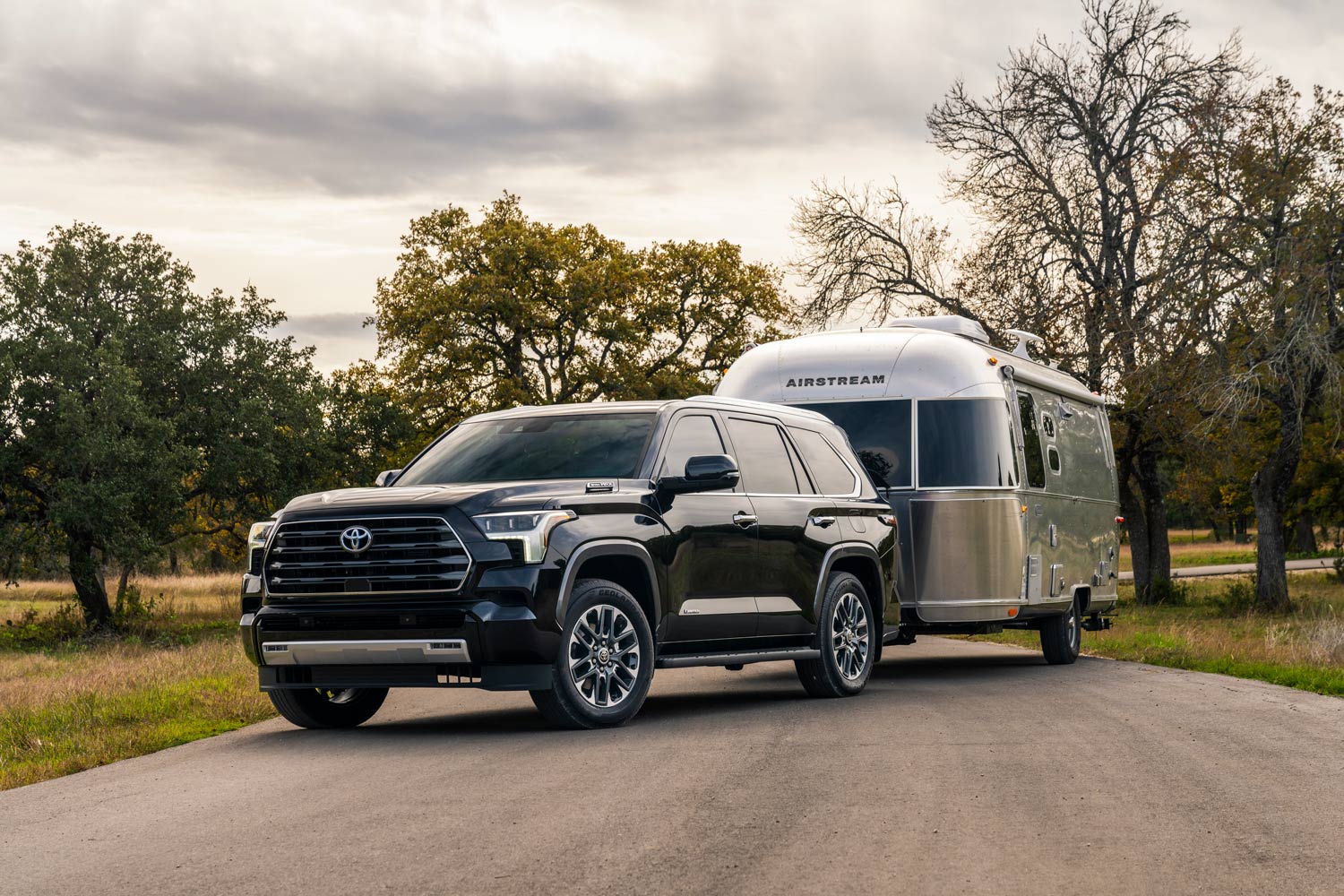 2023 Toyota Sequoia towing an Airstream trailer on a country road