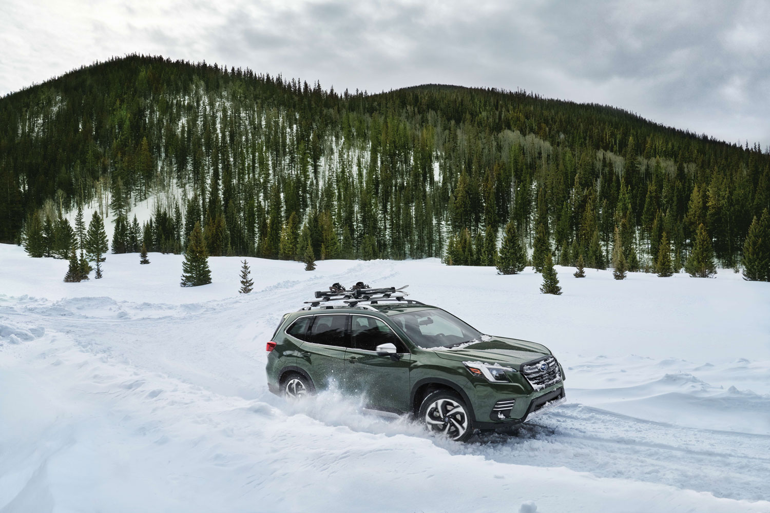 2023 Subaru Forester in green driving on snow