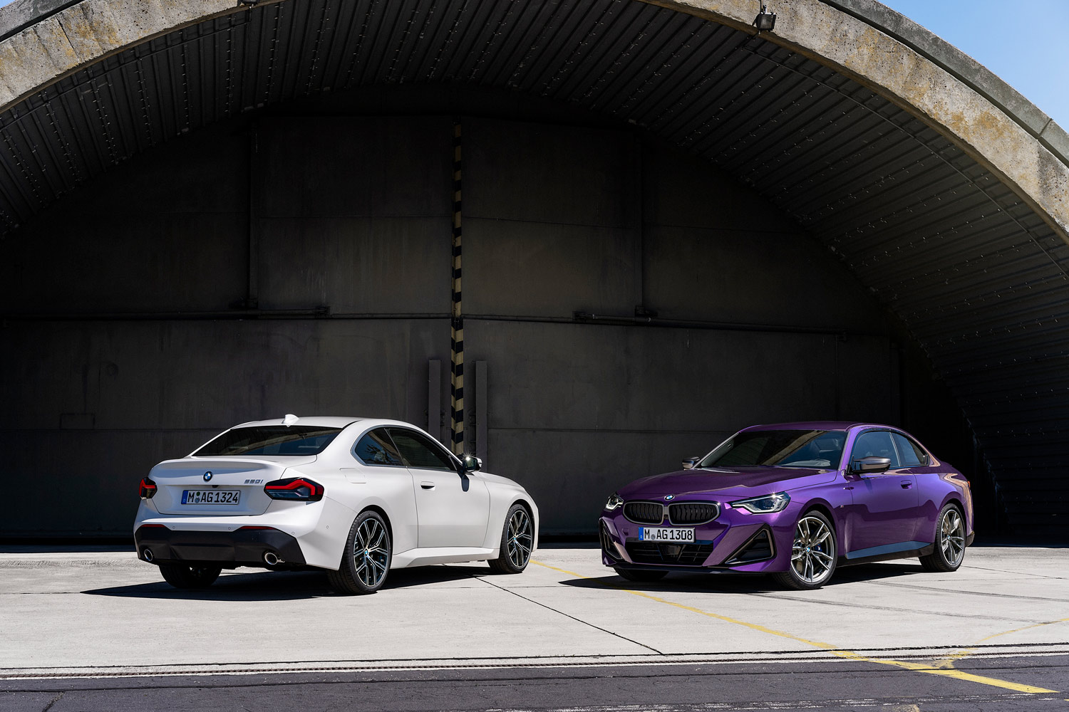 A pair of 2023 BMW 2 Series Coupes, one in white and one in purple