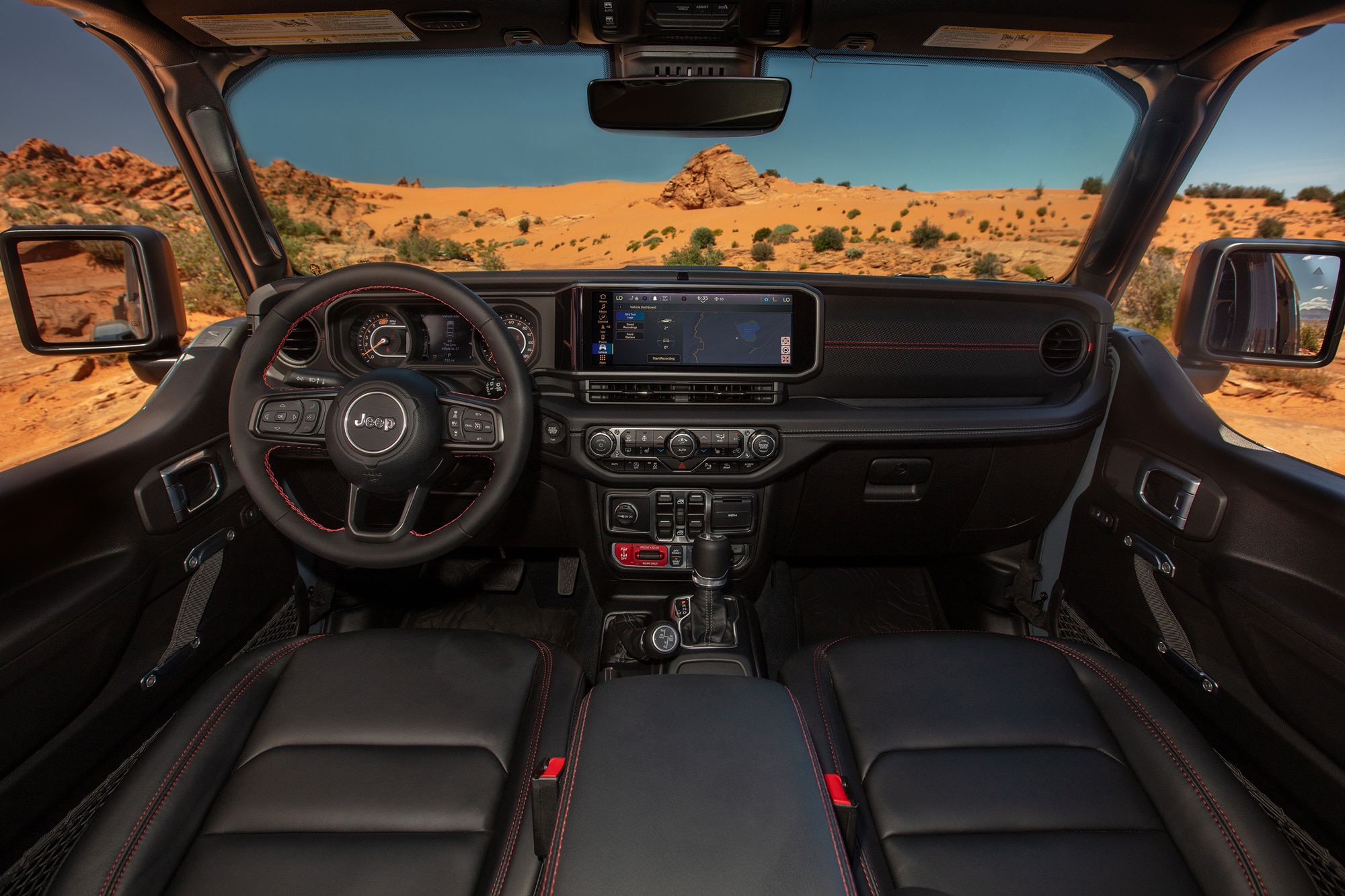 2024 Jeep Wrangler Rubicon X black and red interior looking out into the desert