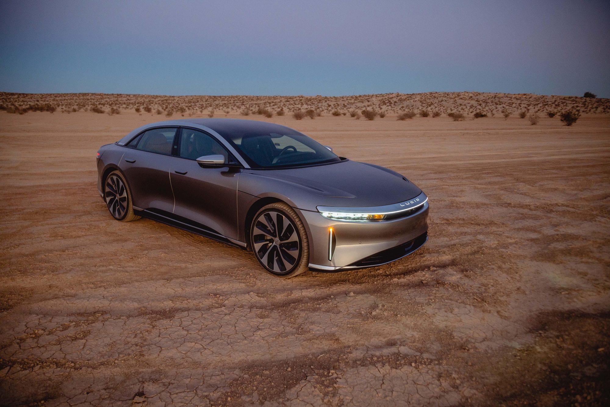 Gray 2022 Lucid Air Grand Touring parked in the Southern California high desert near Joshua Tree at sunset