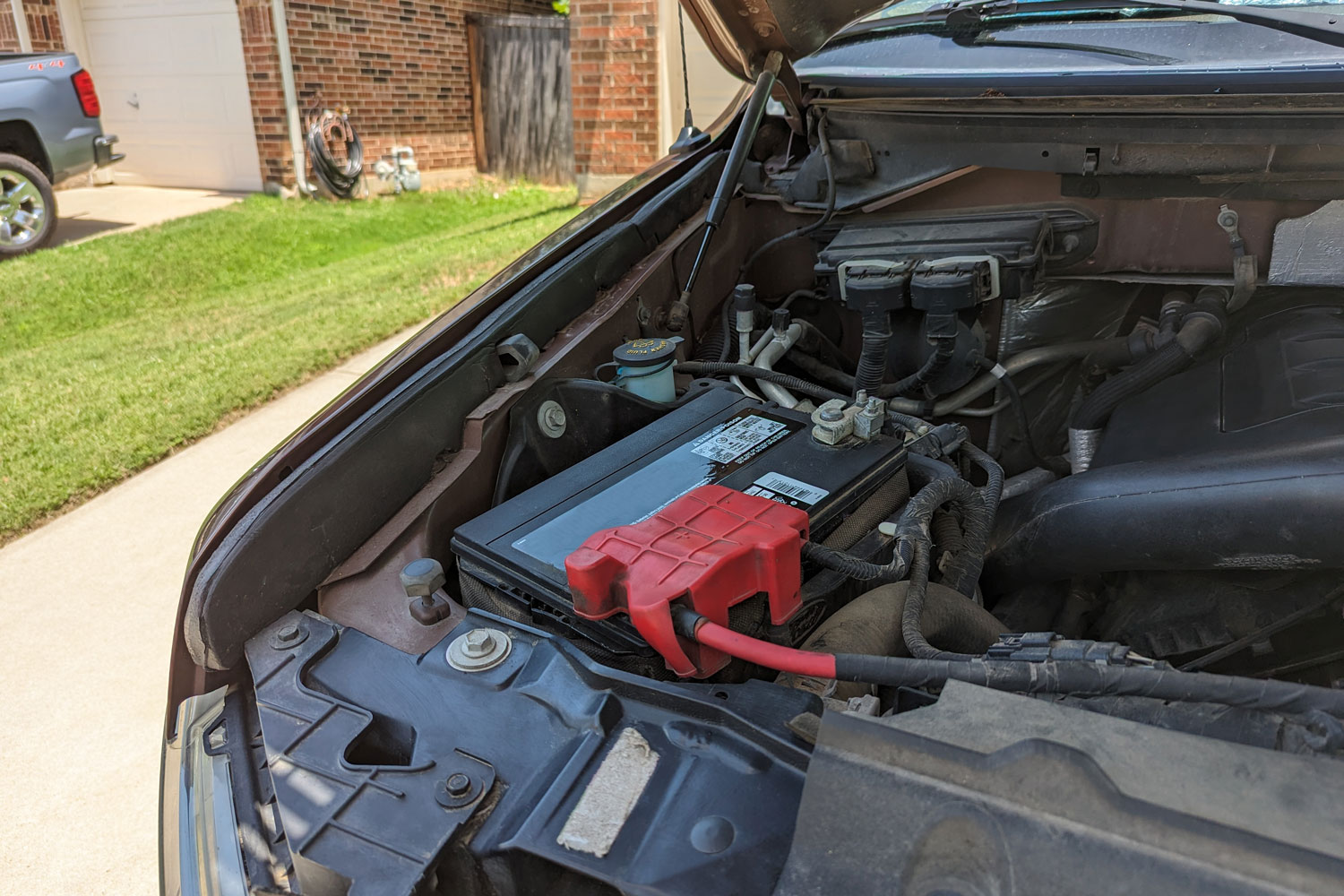 Car battery beneath open truck hood
