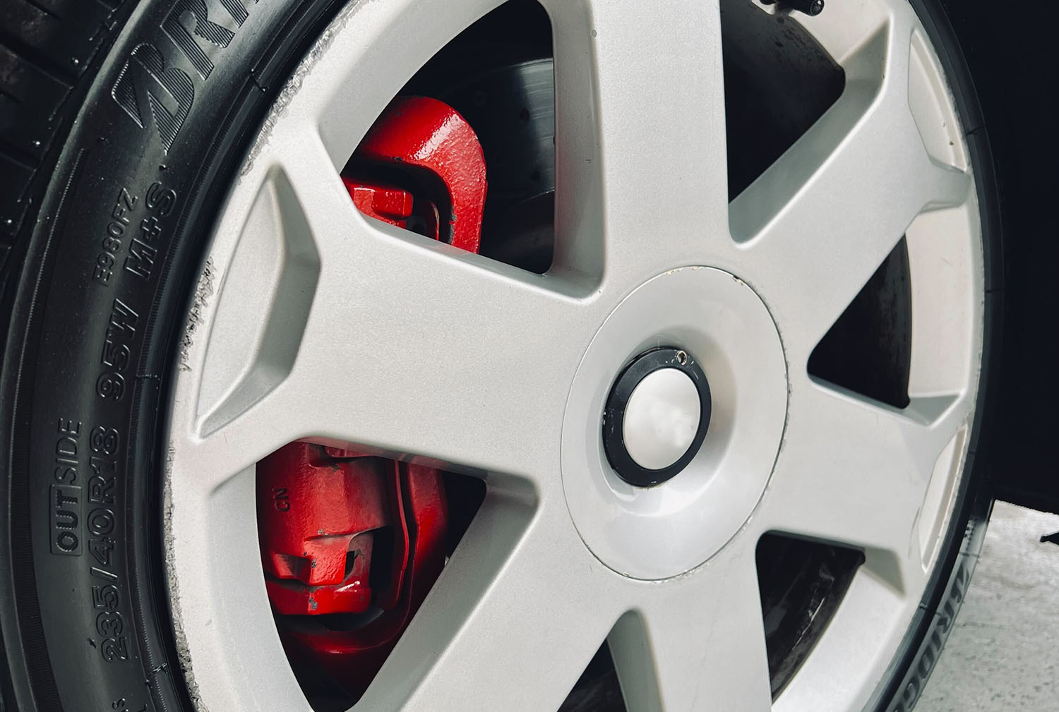  Wheel and tire with view of red brake caliper and brake rotor