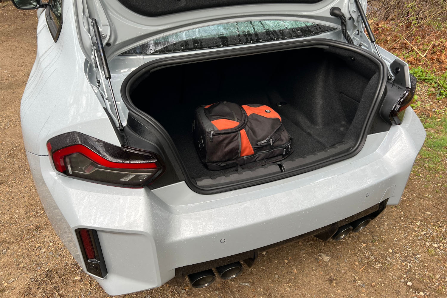 2023 BMW M2 with the trunk lid open, displaying the cargo volume