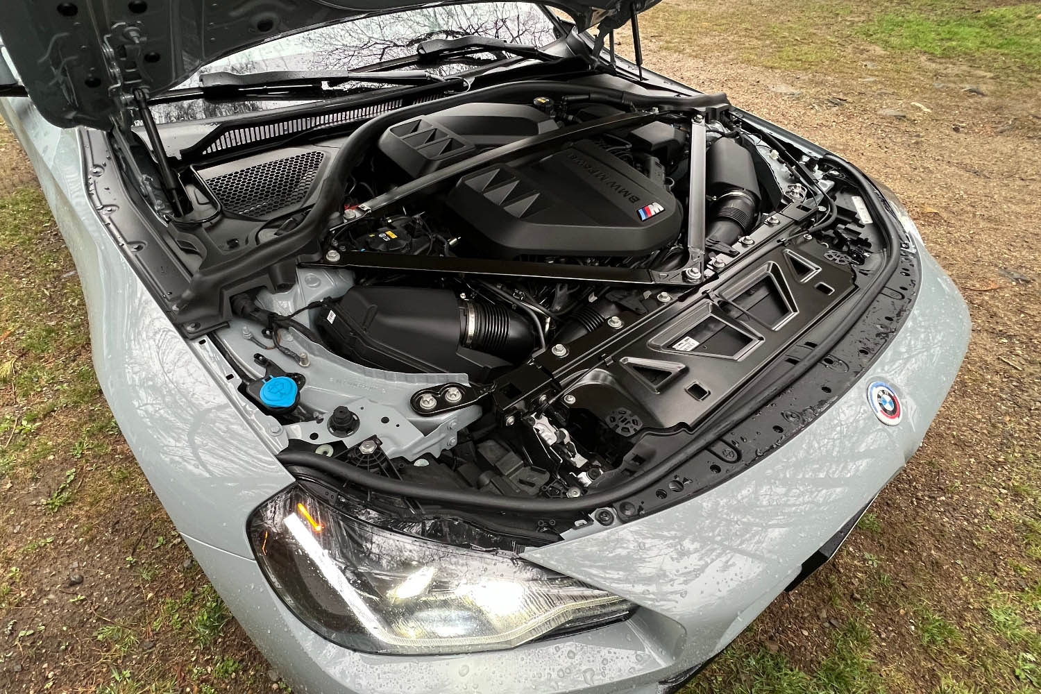 2023 BMW M2 with its hood open, displaying the engine bay