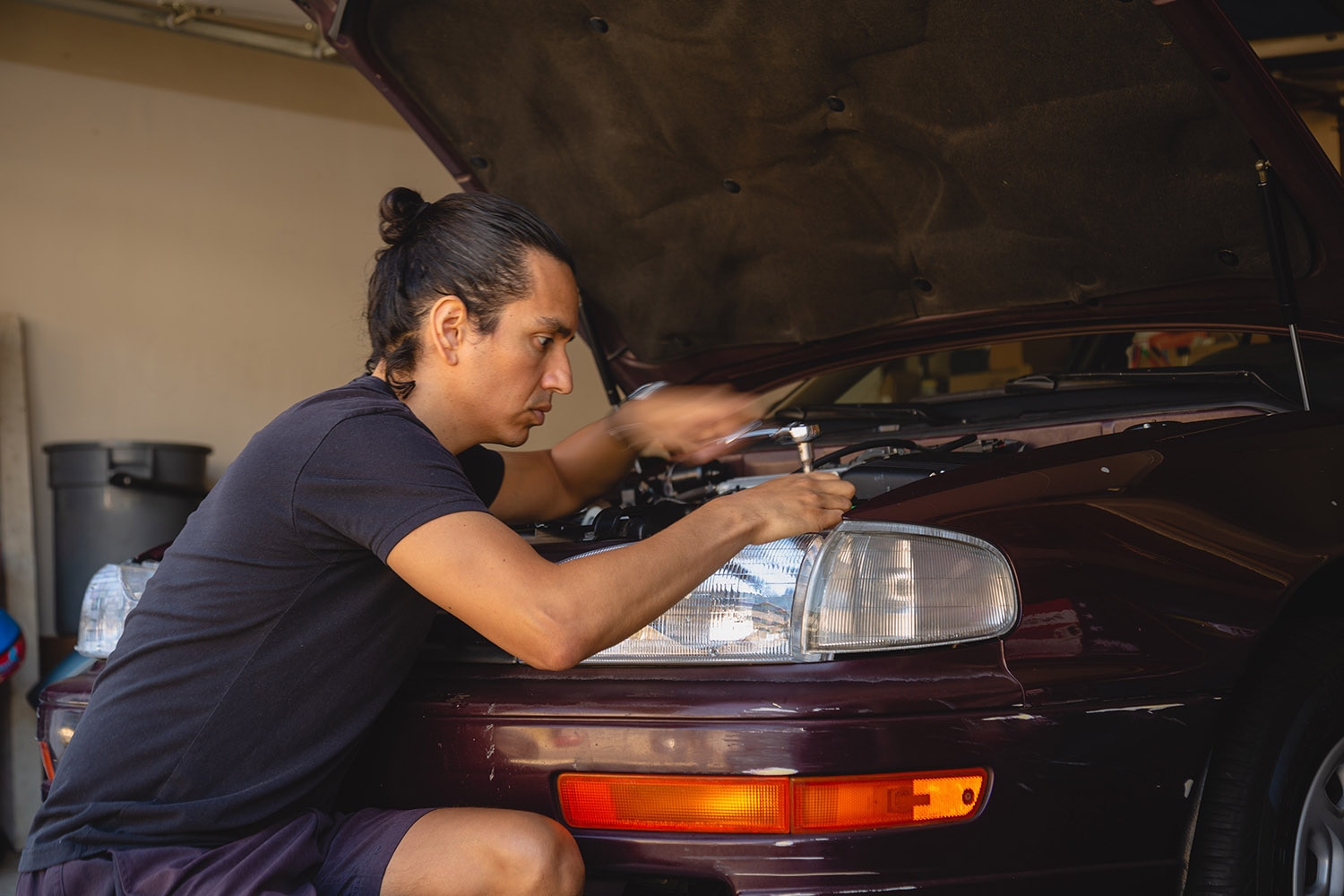 Man working on car with hood open
