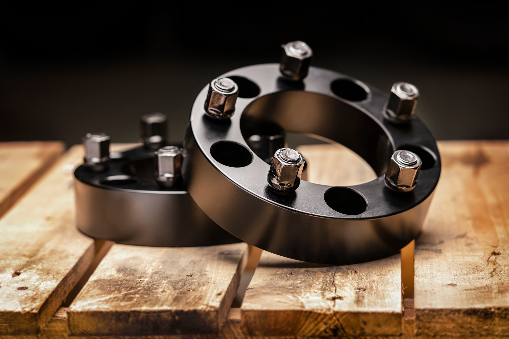 Hub/wheel spacers on a wooden table with black background