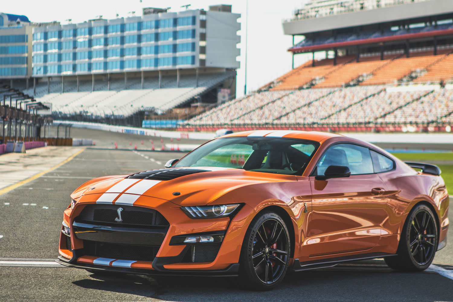 2020 Ford Mustang Shelby GT500 in orange with white stripes parked on a racetrack