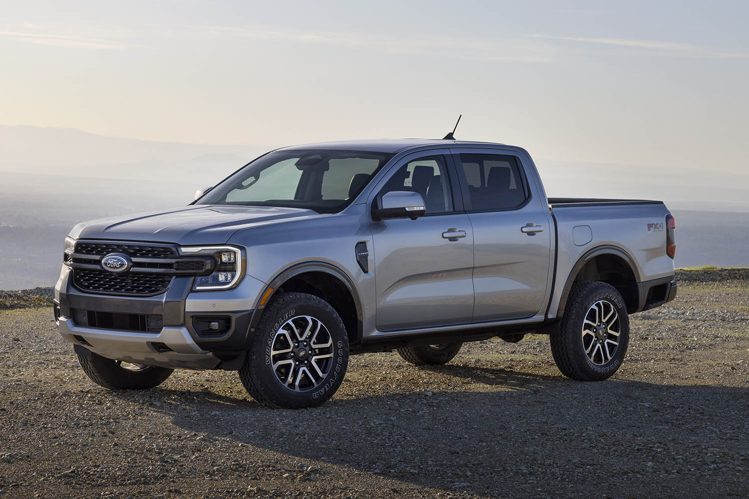 Side view of silver 2024 Ford Ranger Lariat parked on dirt in front of the ocean. 