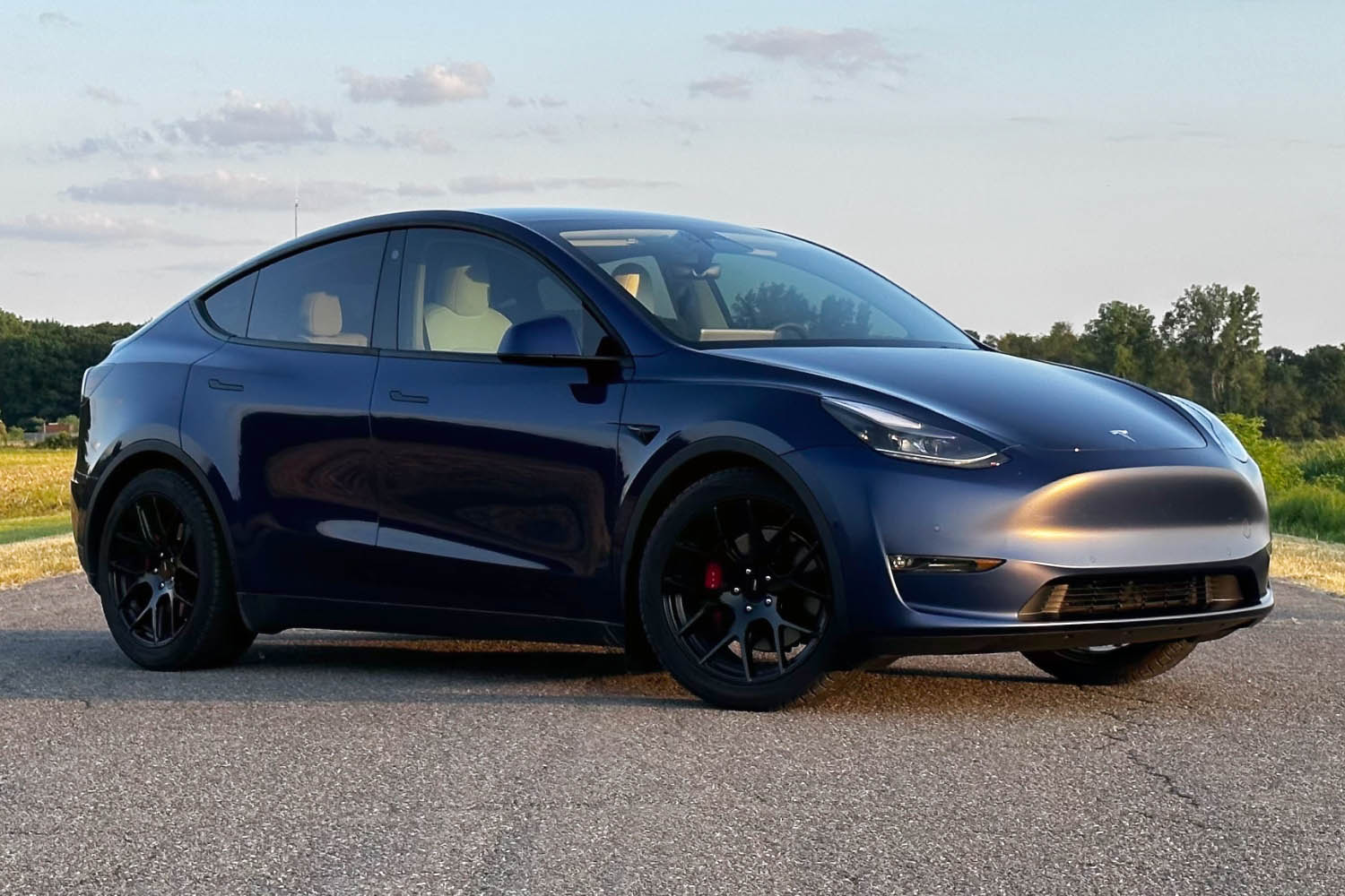  Front three-quarter view of a 2023 Tesla Model Y in dark blue on pavement.