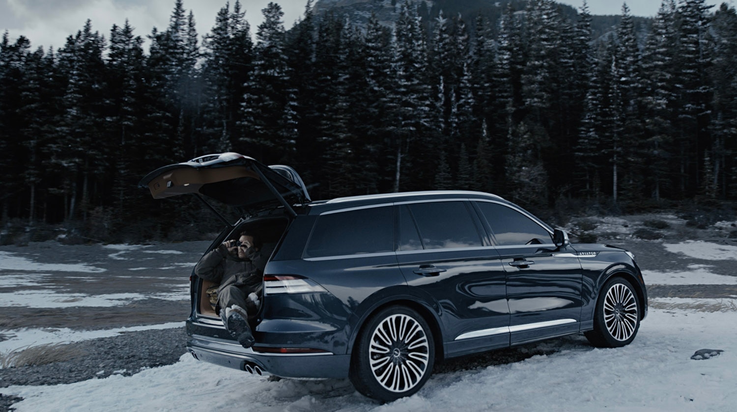 A dark blue 2020 Lincoln Aviator with liftgate open in snowy area