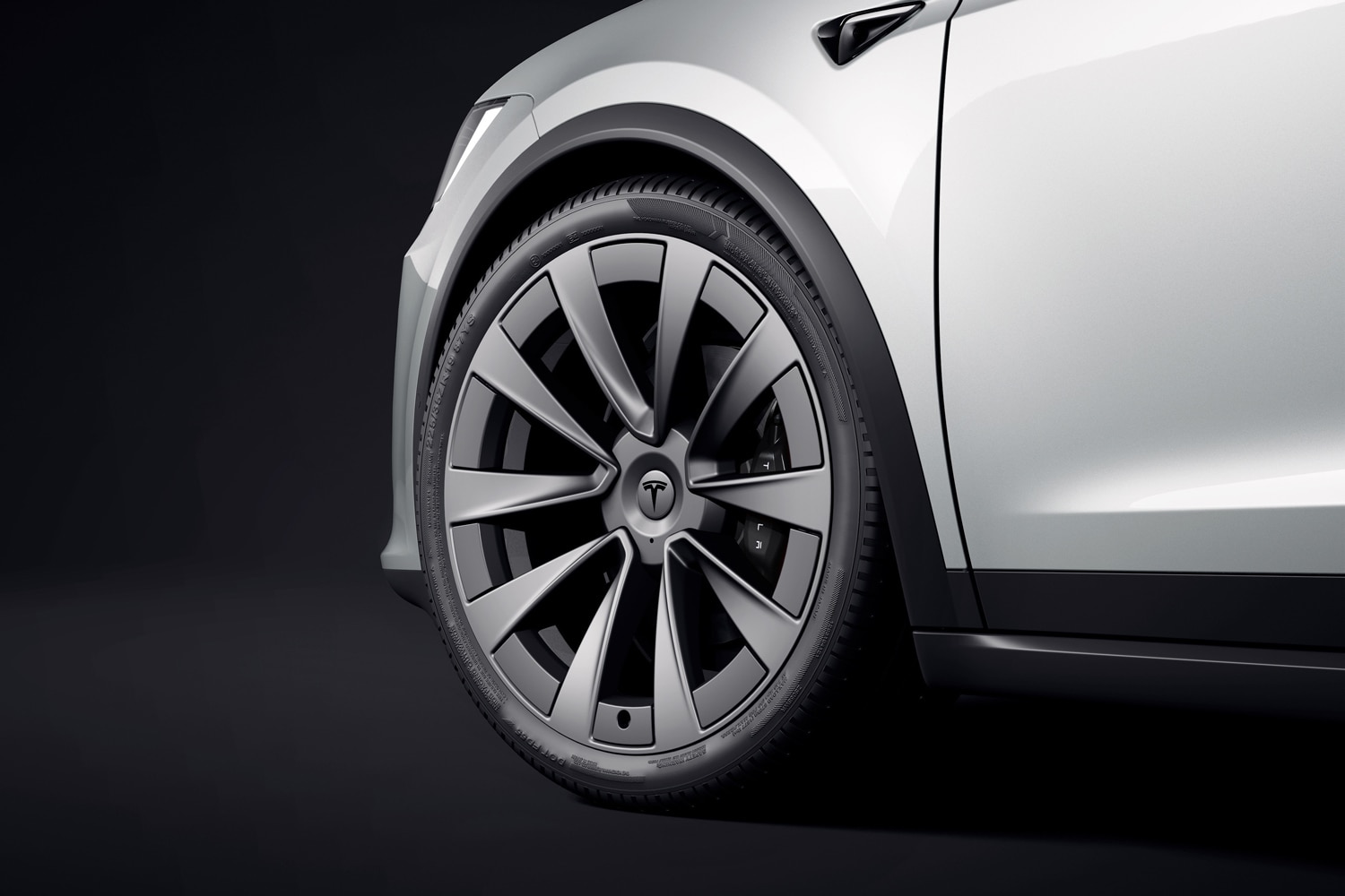 Closeup of a front tire on a white Tesla Model X