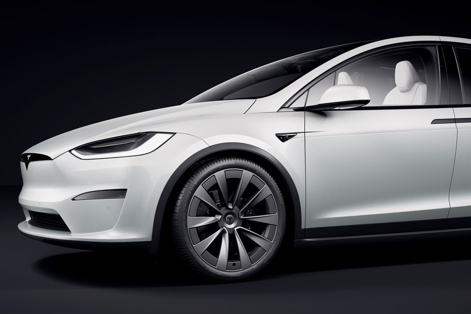 Side of view of the front half of a white Tesla Model X