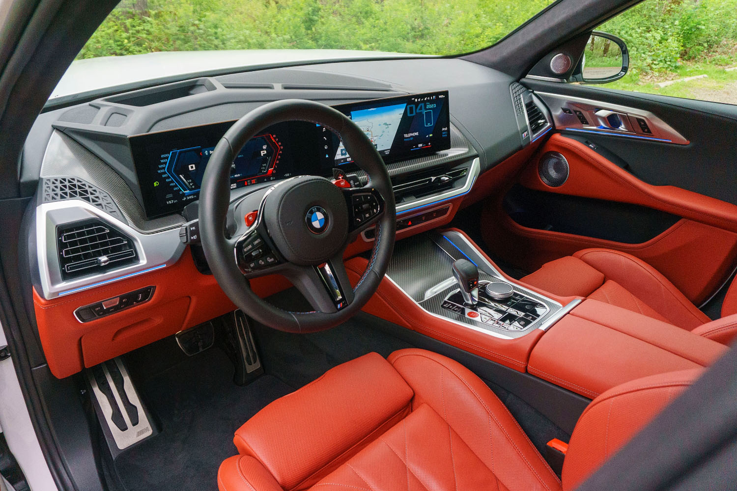 2023 BMW XM interior and dashboard with seats and lower panels in Sakhir Orange