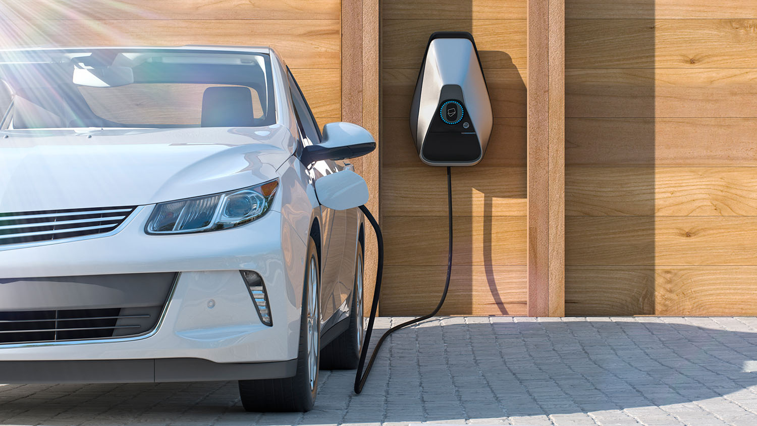A white electric vehicle parked in front of a wall-mounted charger and plugged in