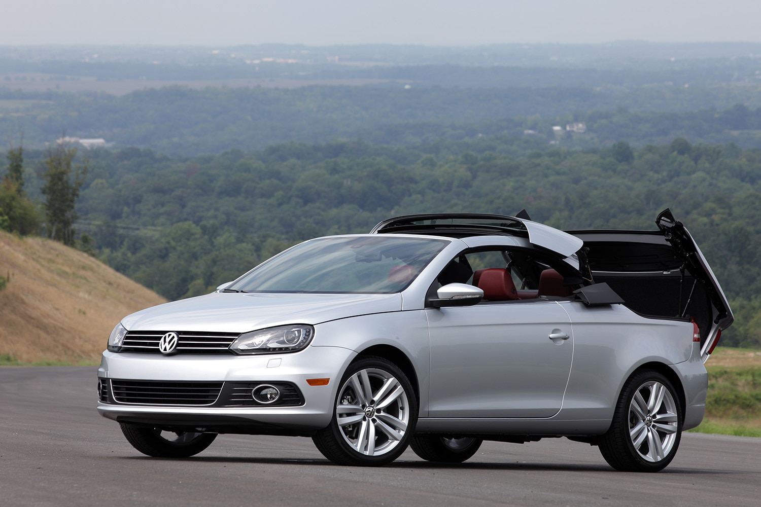 2013 Volkswagen Eos in silver photographed as its convertible hardtop is midway through its opening/closing states.