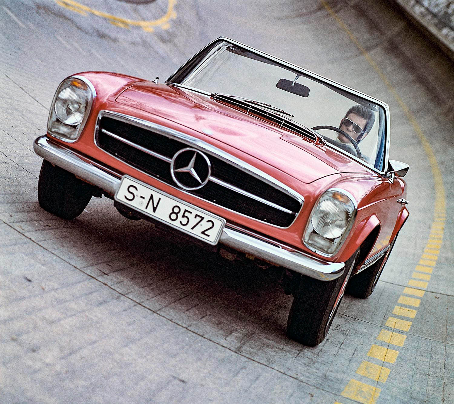Mercedes-Benz 230 SL Pagoda (W113) in red driving along the high banking of Mercedes-Benz's Untertundefinedrkheim test track.