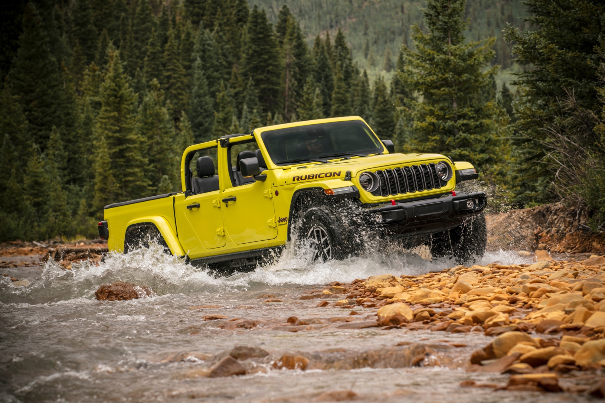 2024 Jeep Gladiator Rubicon in yellow driving over rocky lake