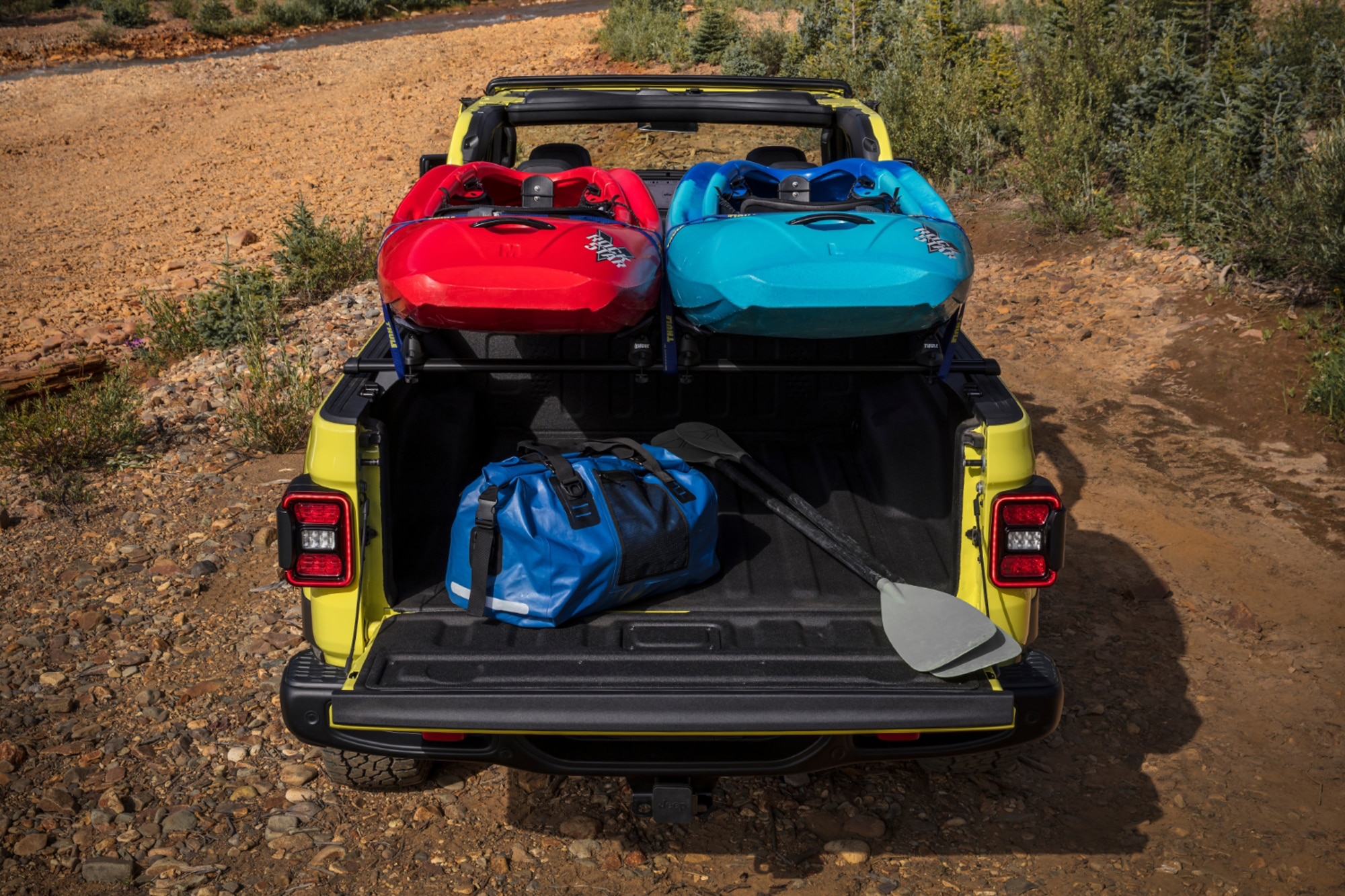 2024 Jeep Gladiator Rubicon truck bed in yellow with kayaks and paddles and duffel bag