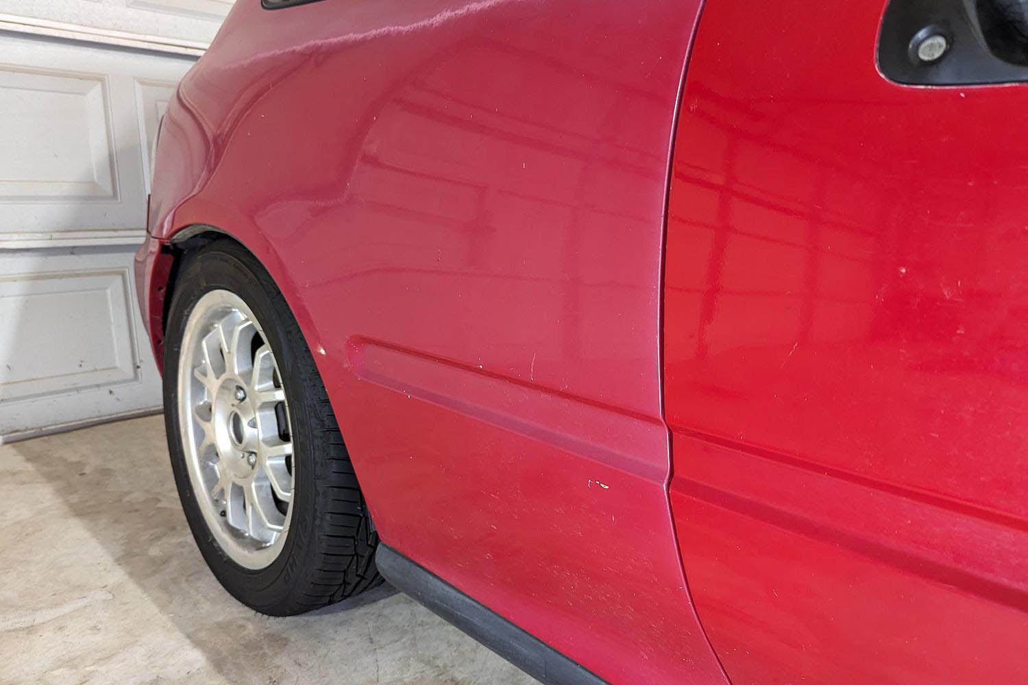 Detail shot of vintage Honda Civic with body panels in different shades of red.