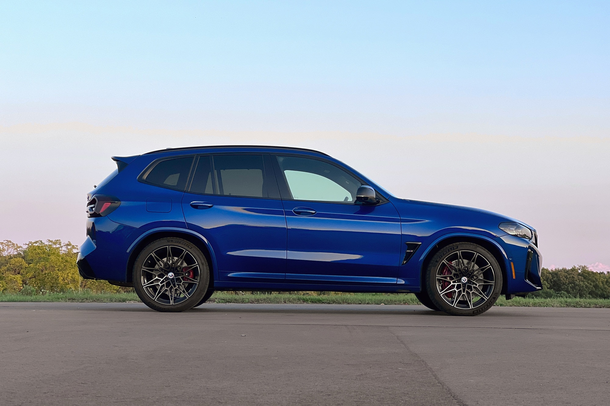 2023 BMW X3 M in Le Mans Blue side view parked next to grass