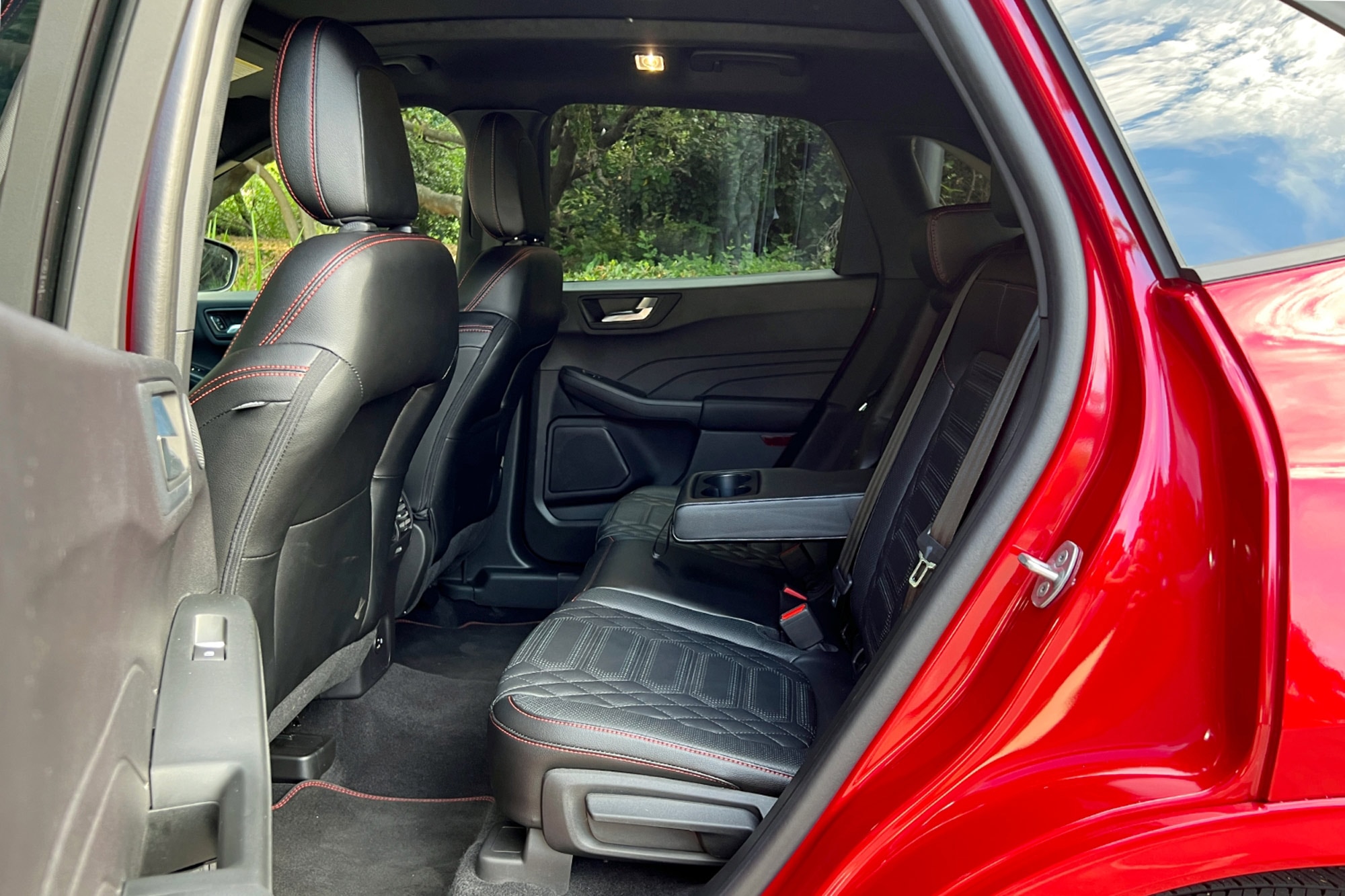 2023 Ford Escape ST-Line Elite in Rapid Red rear passenger seats with window view of forest