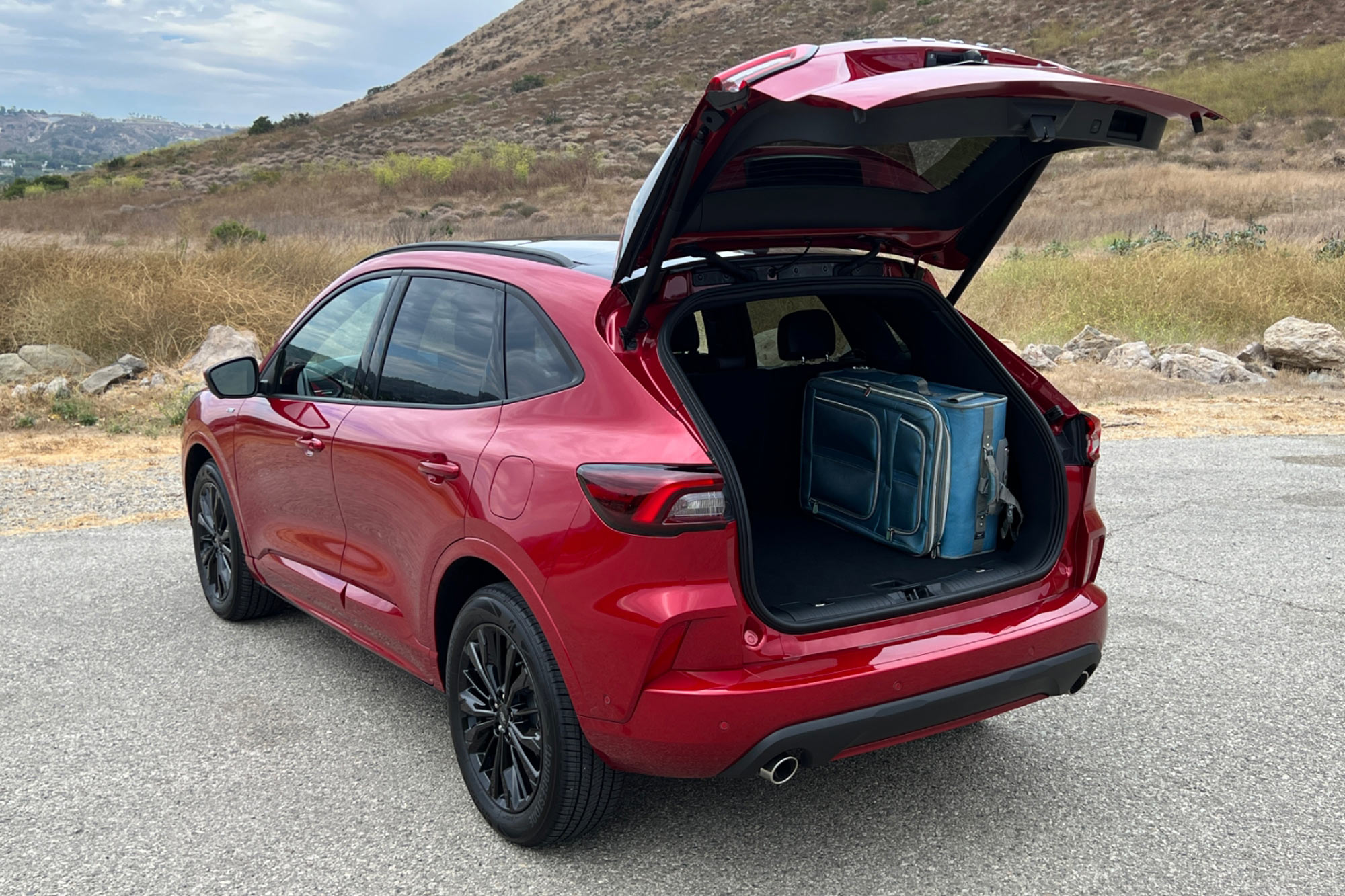 2023 Ford Escape ST-Line Elite in Rapid Red open cargo space with blue suitcase inside