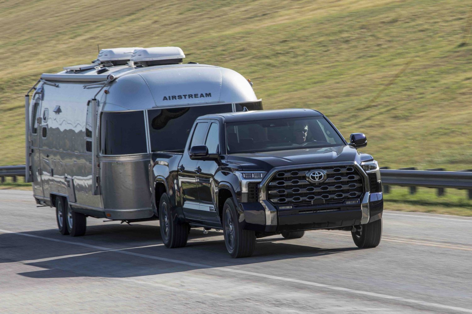 2023 Toyota Tundra pulls an Airstream travel trailer camper along the highway.