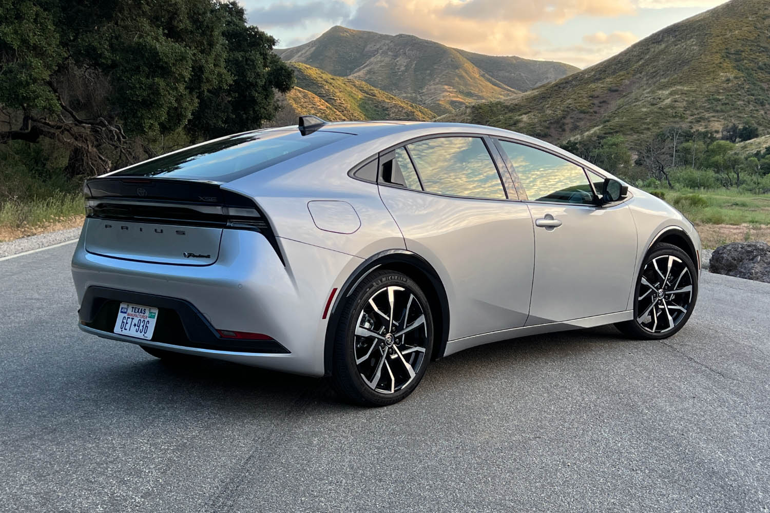 Right rear view of the silver 2023 Toyota Prius Prime in front of mountains