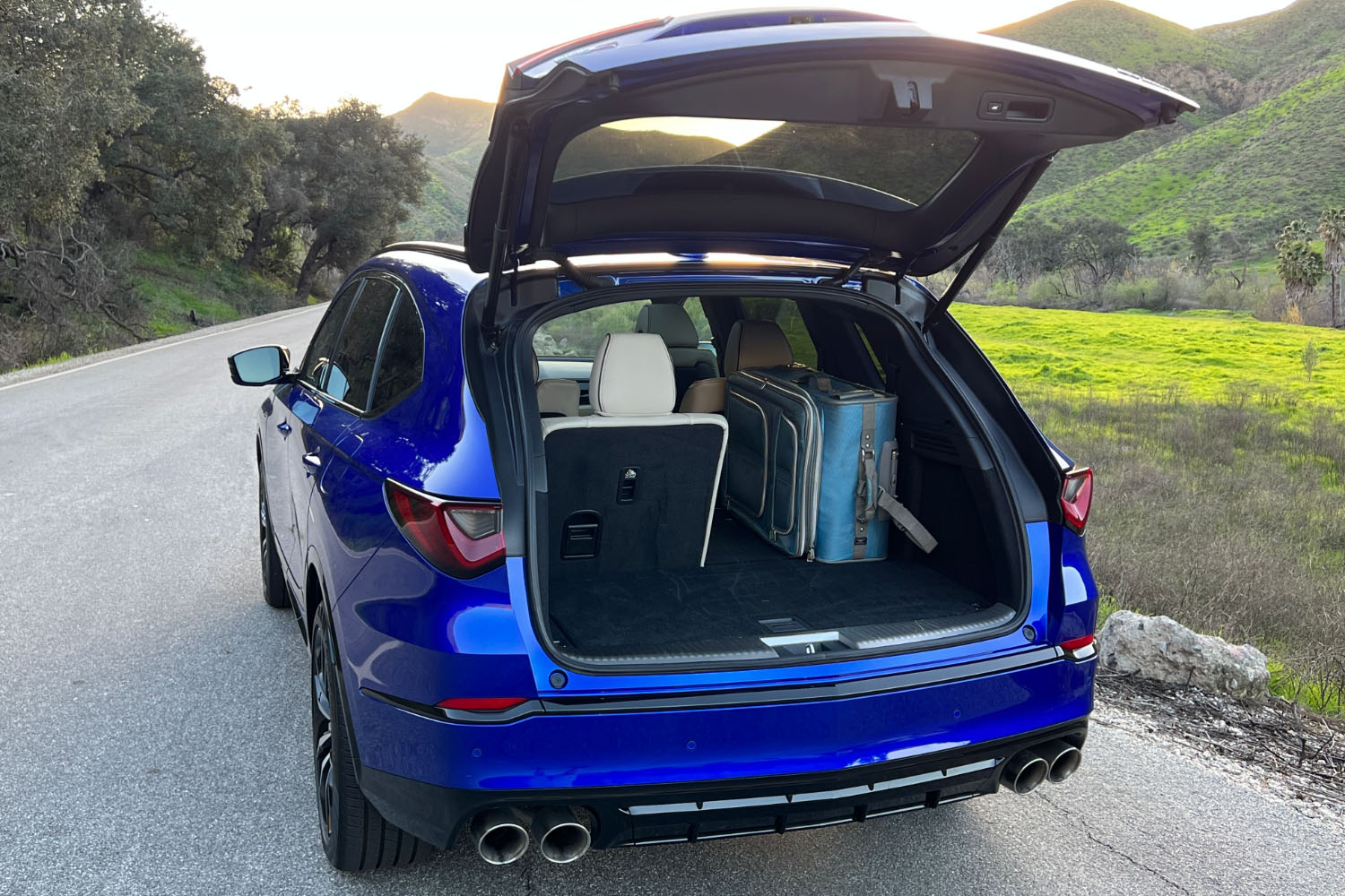 2023 Acura MDX Type S in Apex Blue Pearl with the rear hatch open to display the SUV's cargo space.