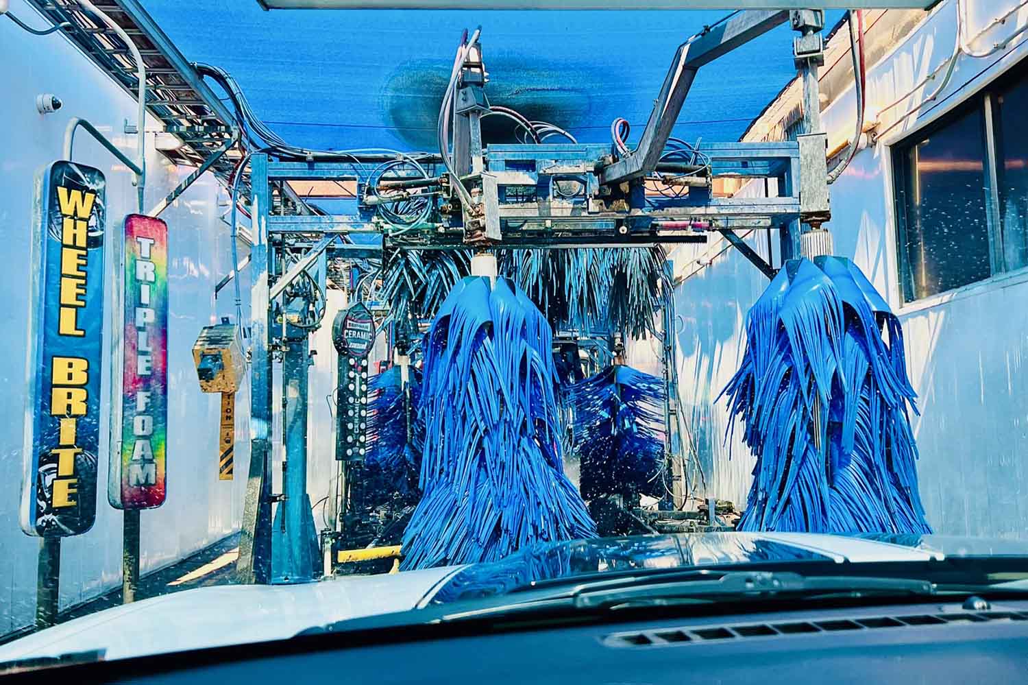 A series of tall brushes inside an automated car wash