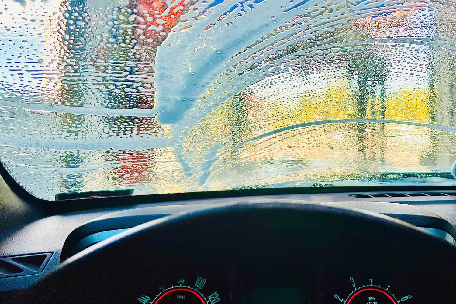 View out a soapy windshield from the driver's seat of a vehicle