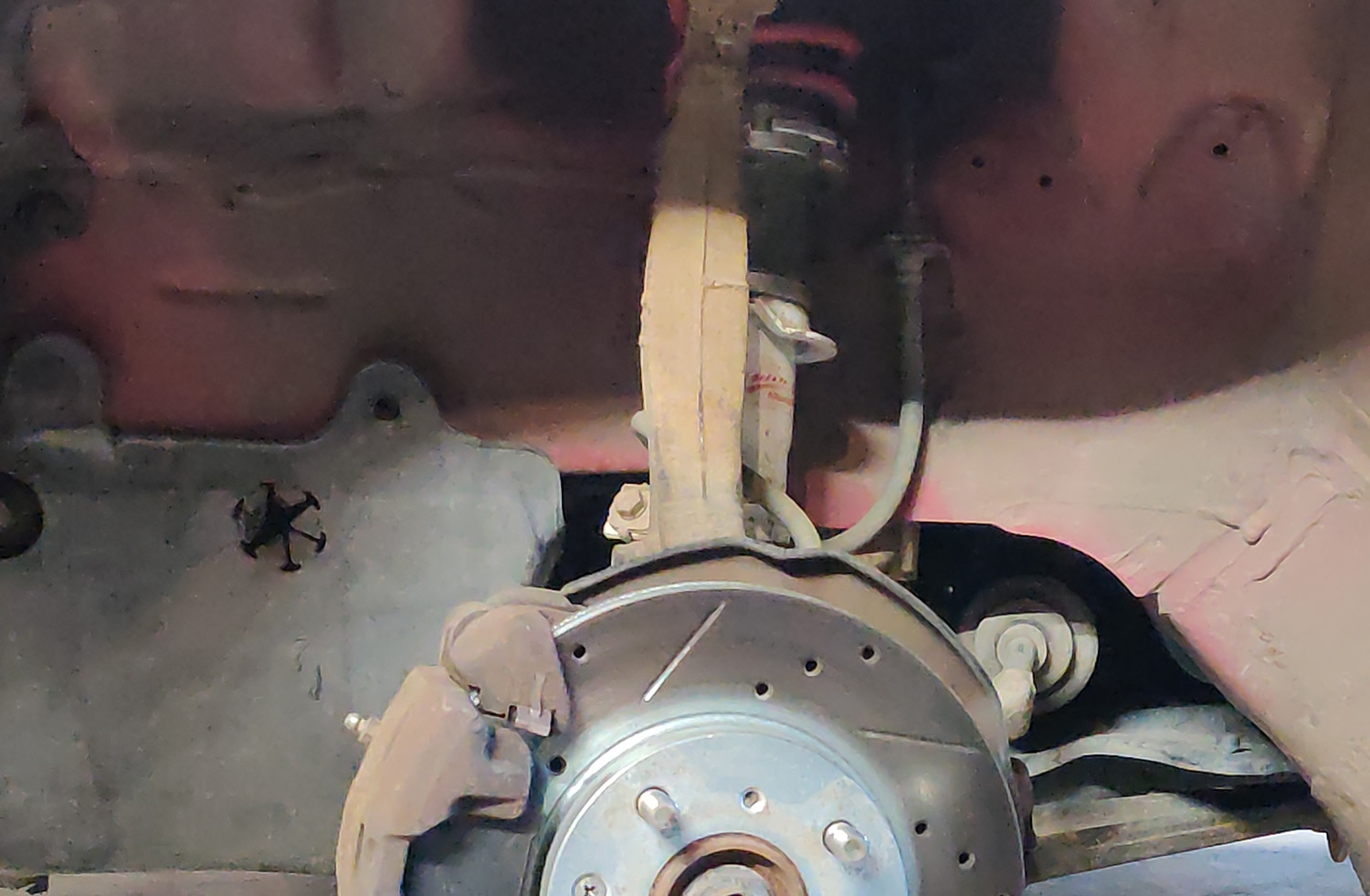 Suspension and braking mechanism in wheel well of vehicle