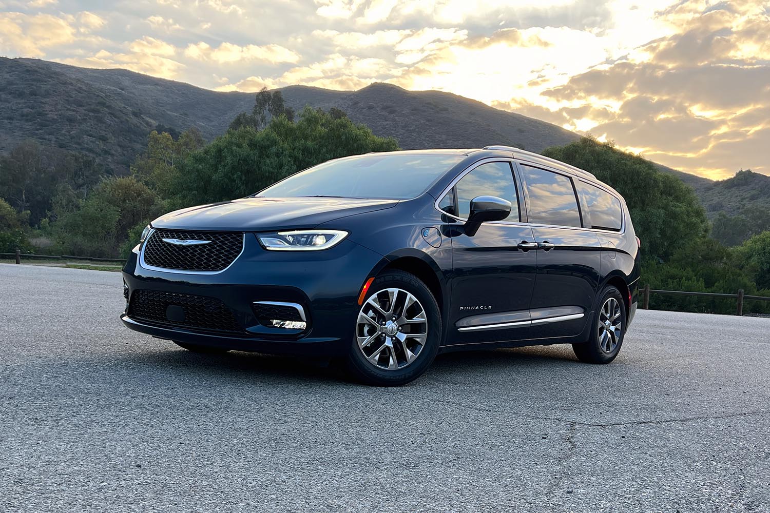 Blue 2023 Chrysler Pacifica Hybrid minivan three-quarter front with mountains