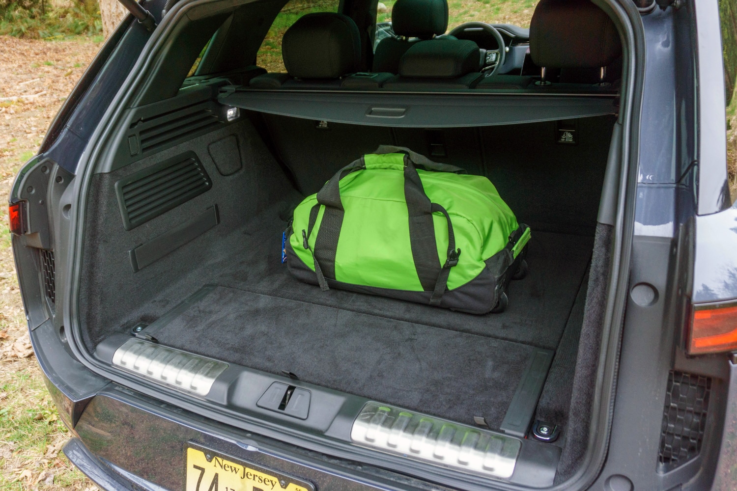 2023 Land Rover Range Rover Sport PHEV rear cargo area with green duffel bag for perspective.