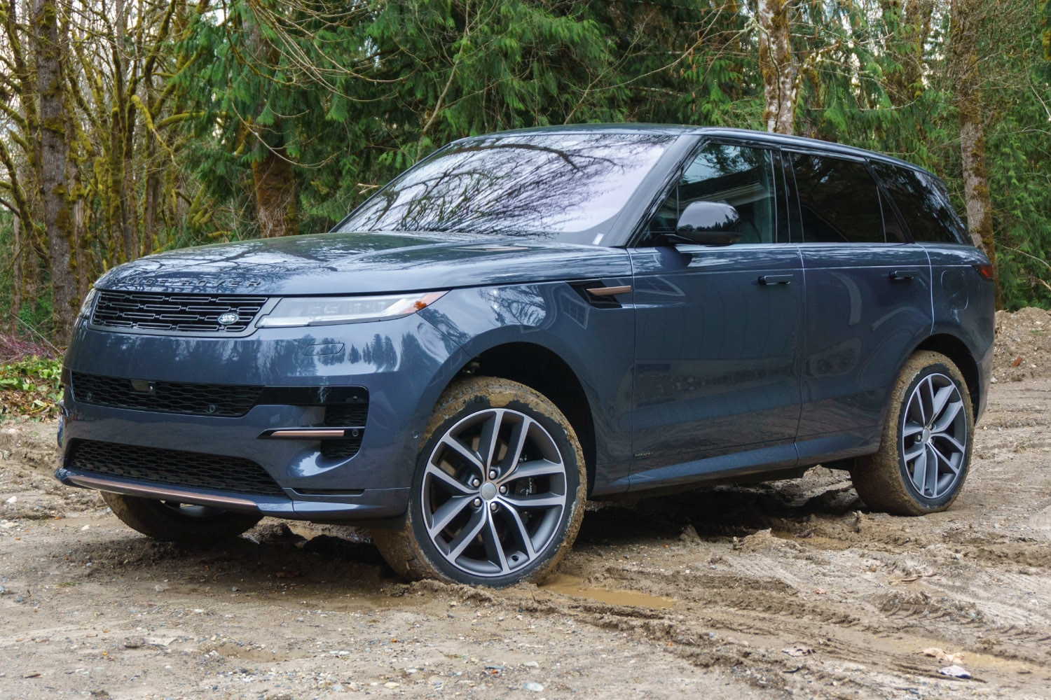 2023 Land Rover Range Rover Sport PHEV in Varesine Blue parked on mud, front-three-quarter view.