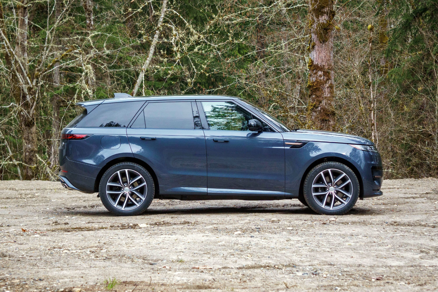 2023 Land Rover Range Rover Sport PHEV in Varesine Blue parked on dirt, side-profile view.