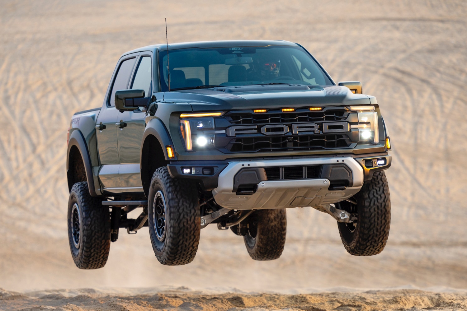 2024 Ford F-150 Raptor slightly off the ground driving on an off-road course.