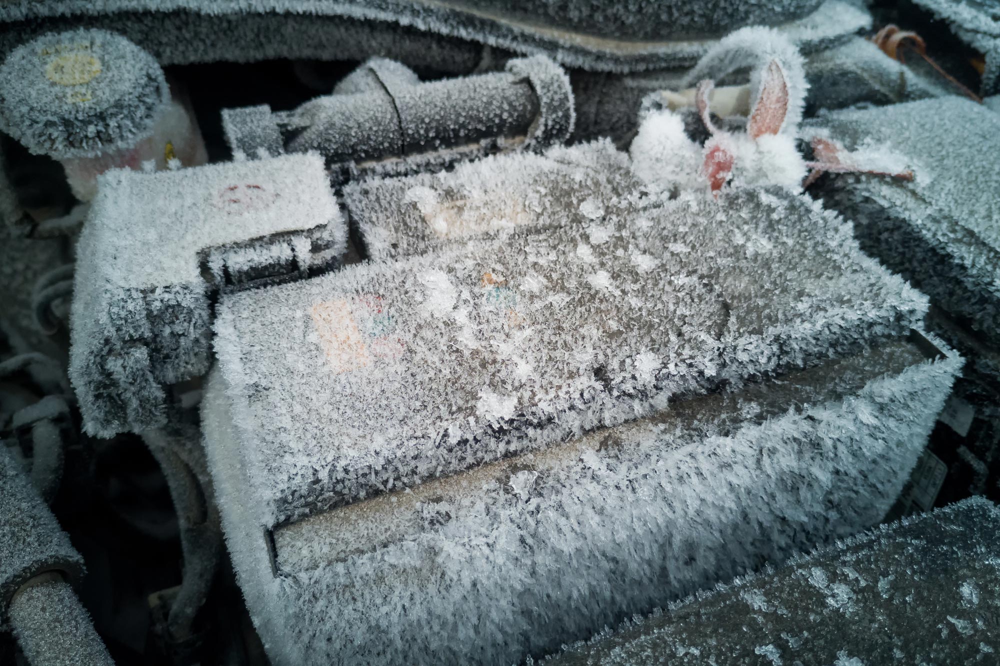 A frozen vehicle battery in the engine bay