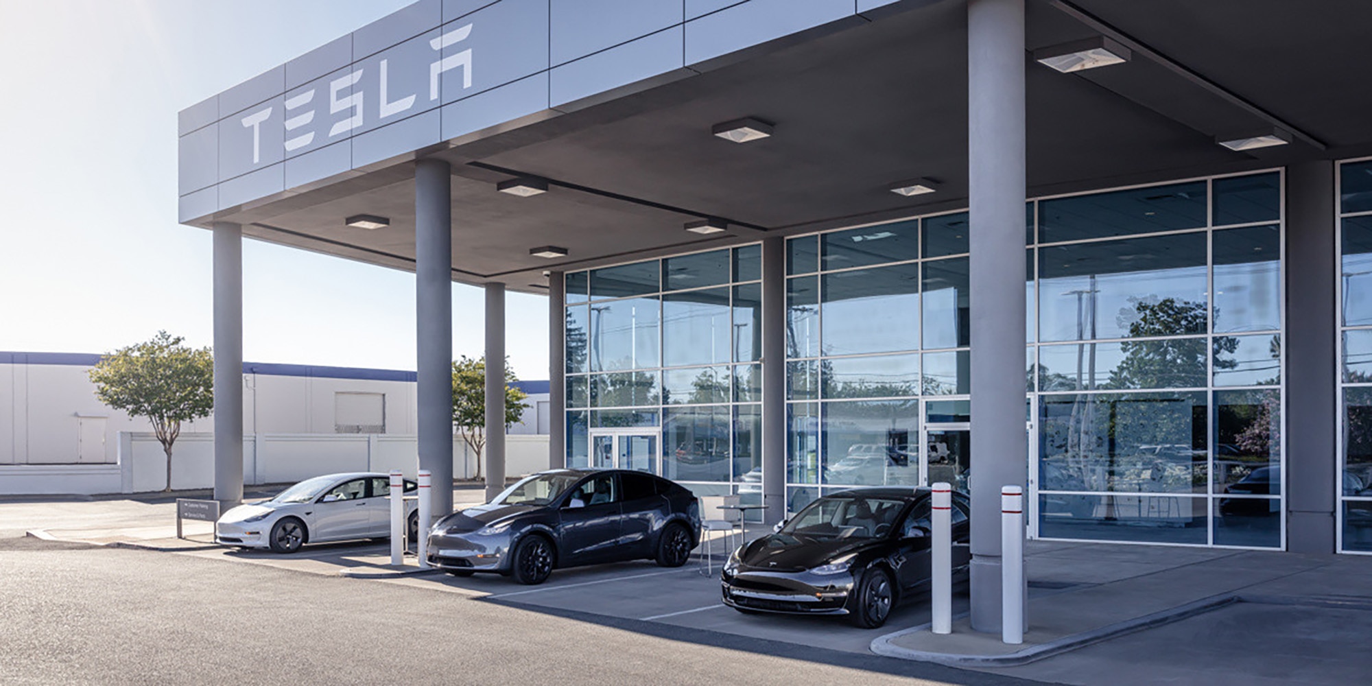 Three Tesla vehicles parked outside a Tesla store