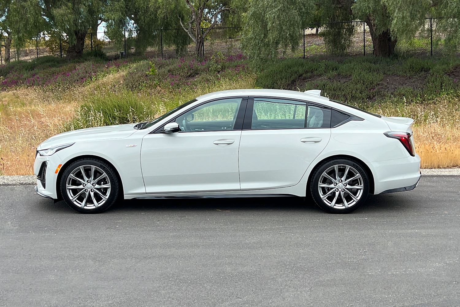 Profile view of a white 2023 Cadillac CT5-V parked along the side of a road
