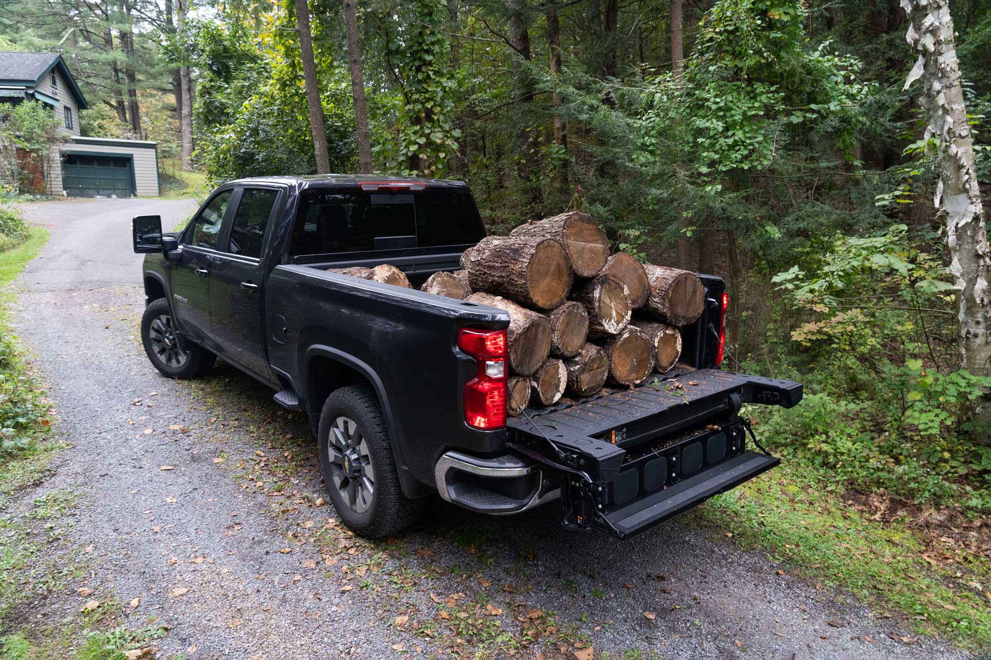 2024 Silverado 2500 HD with bed full of logs and tailgate folder down as a step.