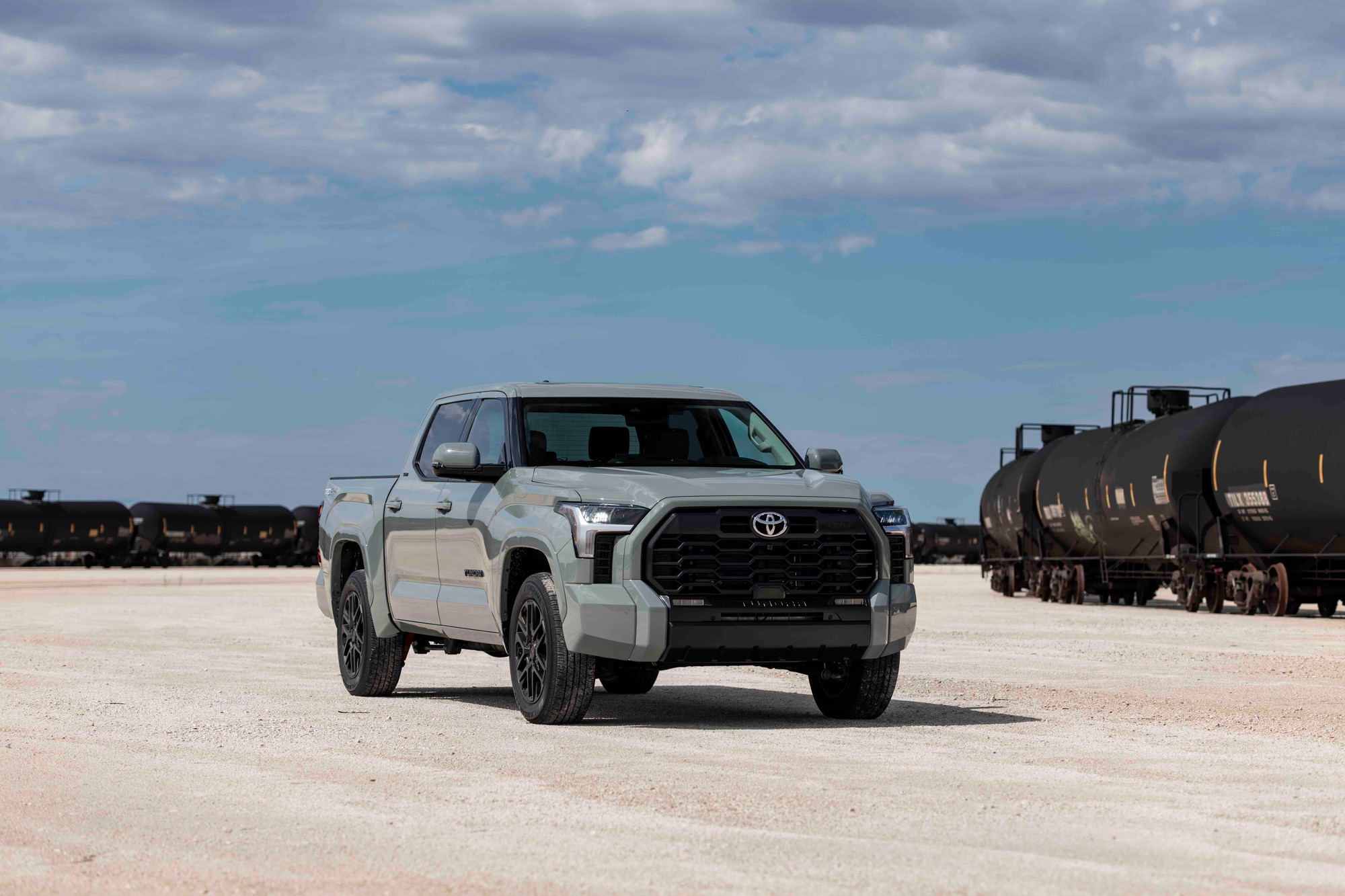 2023 Toyota Tundra parked in the dirt near a number of stationary railcars.