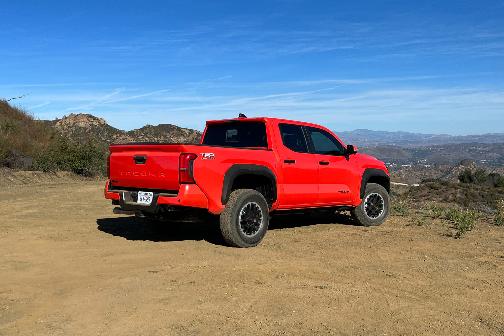 Orange 2024 Toyota Tacoma Off-Road rear view parked in the mountains