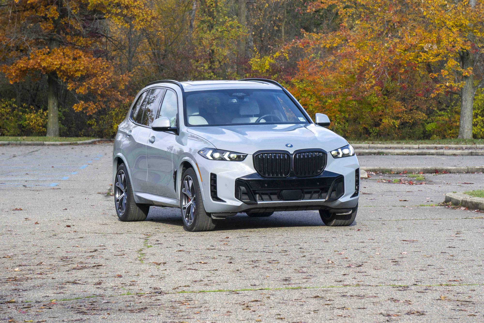 Grey 2024 BMW X5 xDrive50e parked by trees