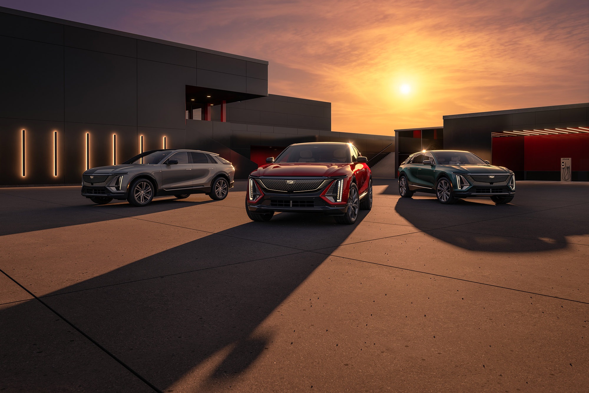 2024 Cadillac Lyriqs in gray, red, and blue parked in front of a sunset.
