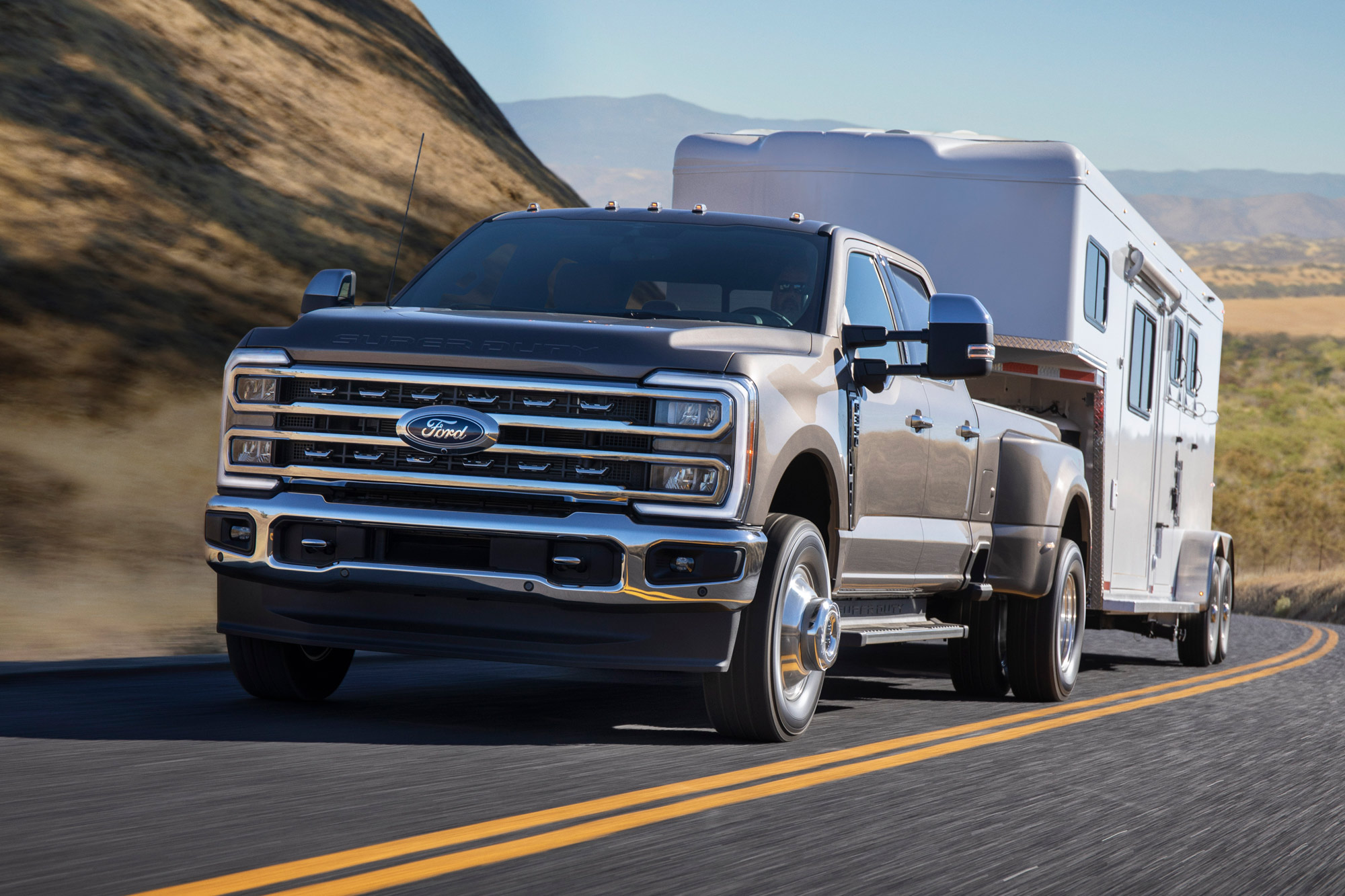 2023 Ford F-350 Super Duty tows a trailer down a highway.