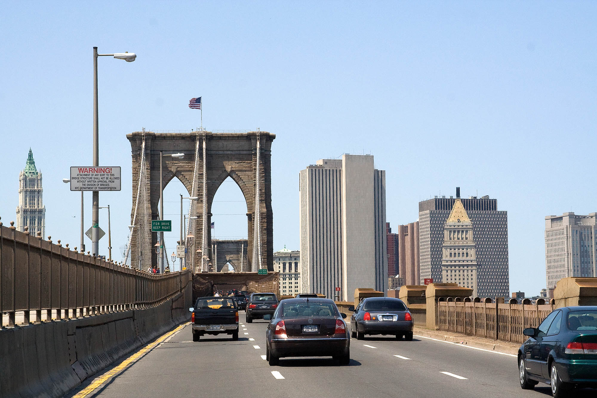 Cars driving on a bridge heading into Manhattan