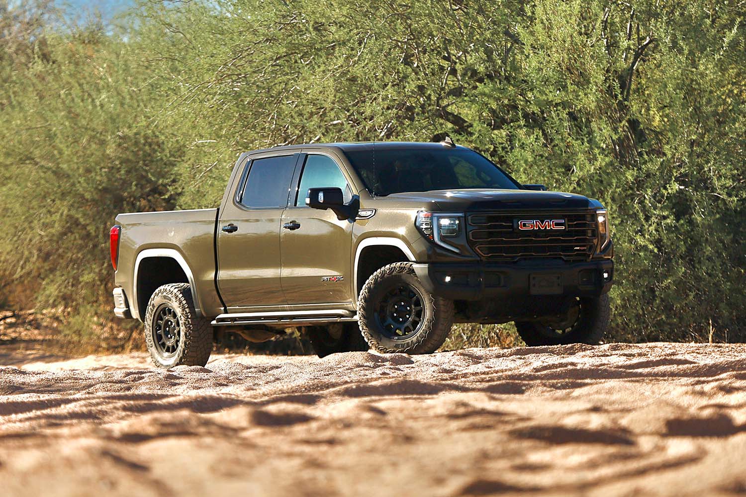 Front right quarter view of a brown 2023 GMC Sierra 1500 AT4X in the dessert